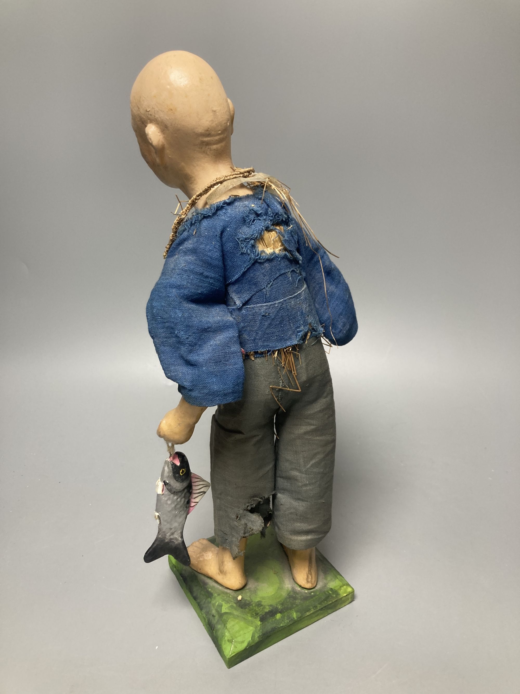An early 20th century Chinese painted composition figure of a fisherman